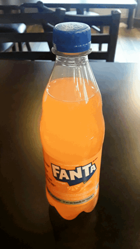 A Bottle Of Orange Fanta Soda On A Table GIF