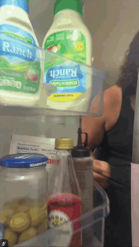 a bottle of ranch salad dressing sits on a shelf in a refrigerator