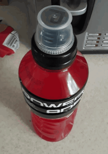 A Bottle Of Red Powerade Sits On A Counter GIF
