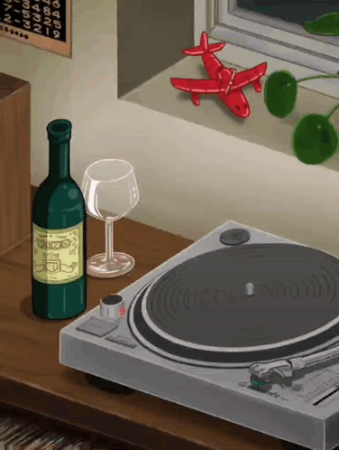A Bottle Of Wine Sits Next To A Record Player And A Glass Of Wine GIF
