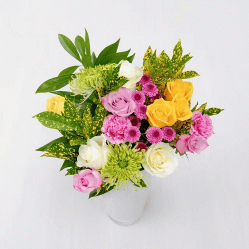 A Bouquet Of Flowers Including Pink Roses And A Yellow Lily GIF