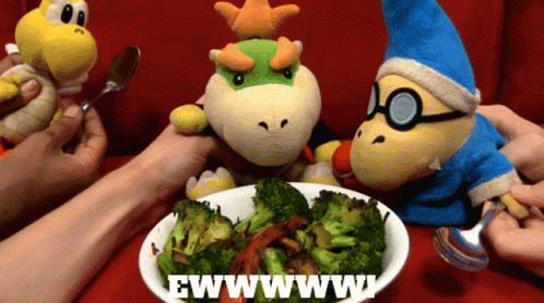 A Bowl Of Broccoli Sits On A Table Next To A Sign That Says Ewww GIF