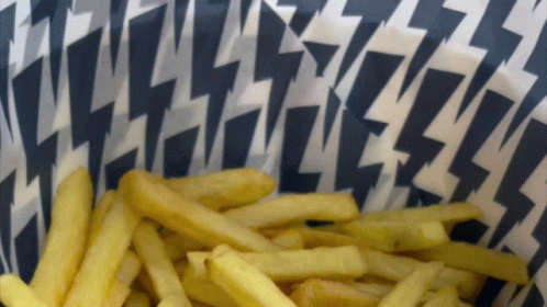 A Bowl Of French Fries With A Lightning Bolt Pattern On The Paper GIF
