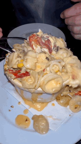 A Bowl Of Macaroni And Cheese With Lobster On Top GIF