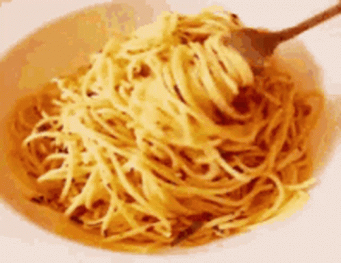 A Bowl Of Noodles With A Spoon In It GIF