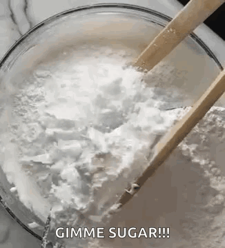 A Bowl Of Sugar With Wooden Spoons In It . GIF