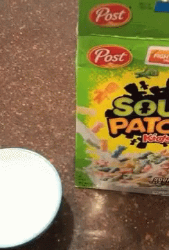 A Box Of Post Sour Patch Kids Cereal Is Next To A Bowl Of Milk GIF