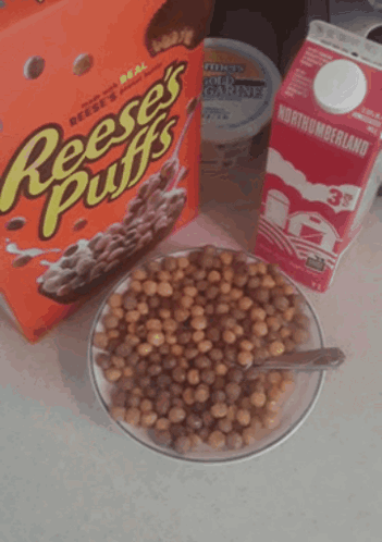 a box of reese 's puffs cereal next to a bowl of cereal and a carton of milk