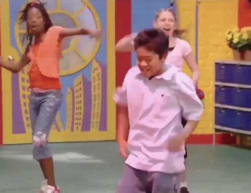 A Boy And A Girl Are Dancing In A Room . GIF