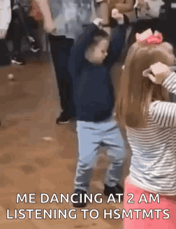 A Boy And A Girl Are Dancing Together In A Room . GIF