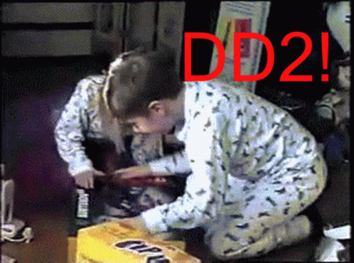 A Boy And A Girl Are Kneeling In Front Of A Box That Says Dd2 GIF