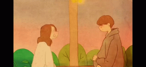 A Boy And A Girl Are Looking At Each Other In A Park . GIF