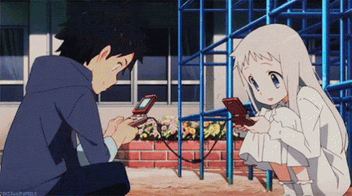 A Boy And A Girl Are Playing A Video Game And The Girl Is Looking At Her Phone GIF