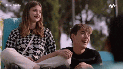 A Boy And A Girl Are Sitting Next To Each Other And The Word Espana Is On The Bottom Of The Screen GIF