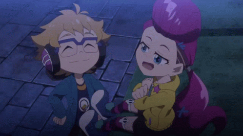 A Boy And A Girl Are Sitting Next To Each Other On A Brick Sidewalk GIF