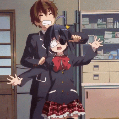 A Boy And A Girl Are Standing Next To Each Other In A Room With A Shelf Full Of Medicine GIF