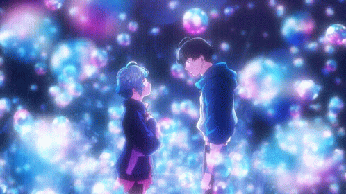 A Boy And A Girl Are Standing Next To Each Other In Front Of Bubbles GIF