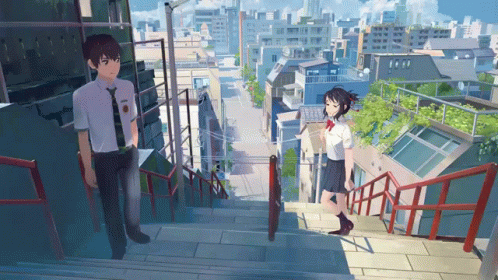 A Boy And A Girl Are Standing On A Set Of Stairs In A City GIF