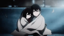 A Boy And A Girl Wrapped In A Blanket Are Hugging Each Other . GIF