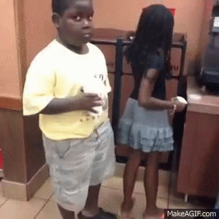 A Boy And Girl Are Standing Next To Each Other In A Restaurant . GIF