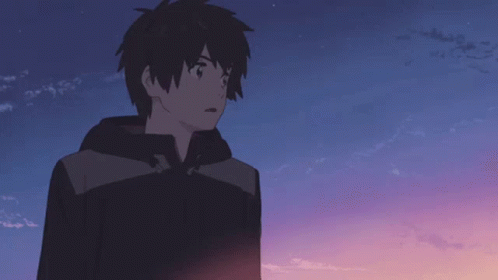 A Boy In A Black Jacket Stands In Front Of A Blue Sky GIF