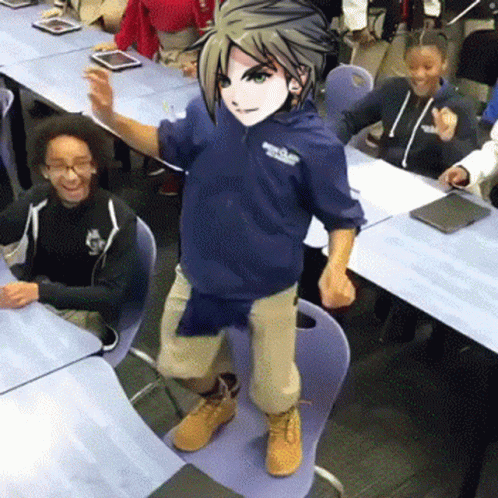 A Boy In A Blue Hoodie Is Standing On A Chair In Front Of A Classroom Full Of Children . GIF