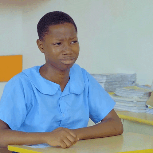 A Boy In A Blue Shirt Sits At A Table GIF