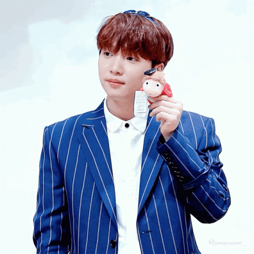 A Boy In A Blue Striped Suit Holds A Stuffed Animal GIF