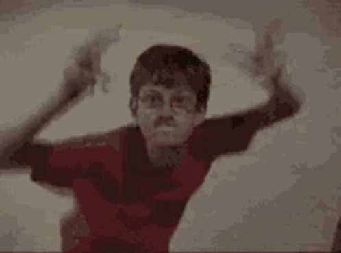 A Boy In A Red Shirt And A Boy In A Black Tank Top Are Standing Next To Each Other . GIF