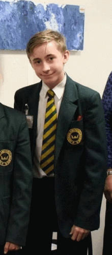 A Boy In A School Uniform Has A Patch On His Jacket That Says ' Williams ' On It GIF