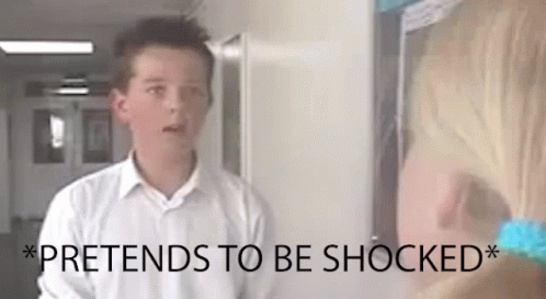 A Boy In A White Shirt Is Standing Next To A Girl In A Hallway And The Girl Is Shocked . GIF