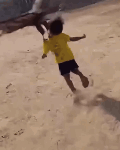 A Boy In A Yellow Shirt Is Being Attacked By A Bird GIF