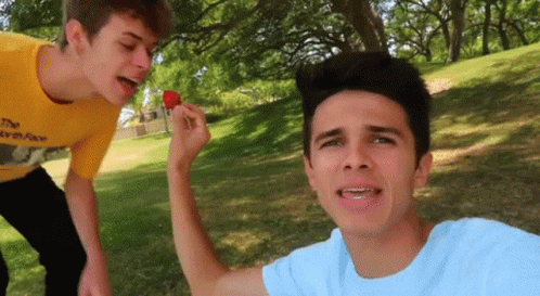 A Boy In A Yellow Shirt Is Eating A Strawberry GIF