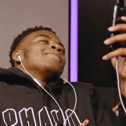 A Boy Is Feeling Giddy Looking At His Phone GIF