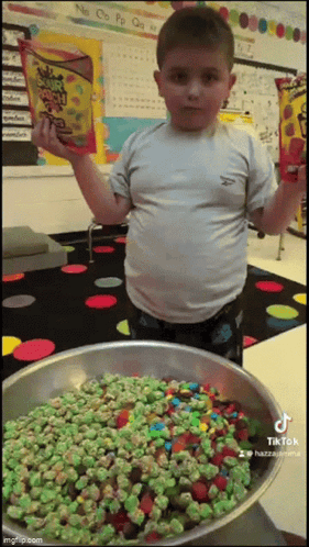 A Boy Is Holding A Bag Of Jelly Belly Candy GIF