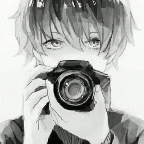 A Boy Is Holding A Camera In Front Of His Face . GIF