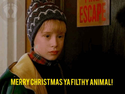 A Boy Says Merry Christmas Ya Filthy Animal In Front Of A Sign That Says Escape GIF