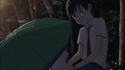 A Boy Sits Under An Umbrella With His Head Down GIF