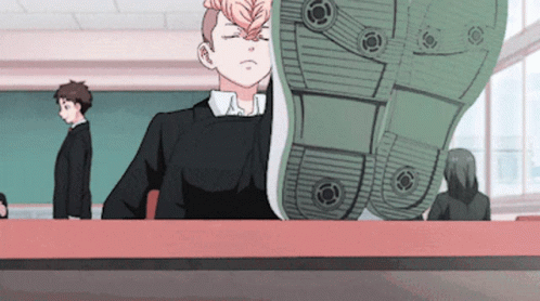 A Boy Sitting At A Desk With His Eyes Closed And A Shoe On His Head GIF