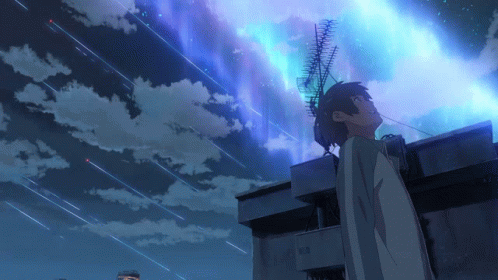 A Boy Stands On The Roof Of A Building Looking Up At The Night Sky GIF