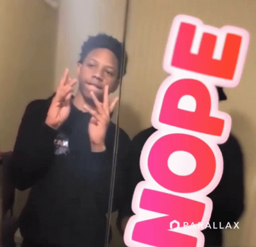 A Boy Taking A Picture Of Himself In A Mirror With A Sticker That Says Nope On It GIF
