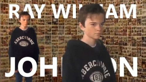 a boy wearing a black abercrombie sweatshirt stands in front of a wall