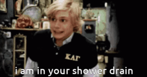 A Boy Wearing A Black Shirt That Says Kappa On It Says I Am In Your Shower Drain GIF