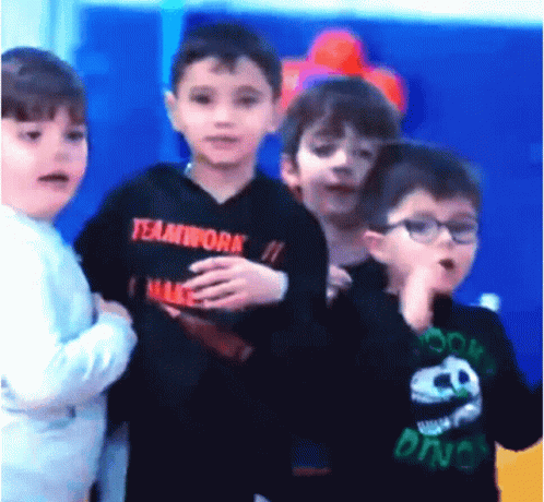 A Boy Wearing A Black Teamwork Shirt Stands In A Line With Other Children GIF