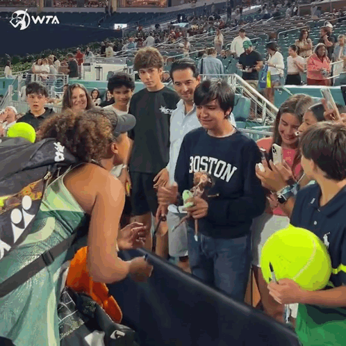A Boy Wearing A Boston Sweatshirt Is Surrounded By People GIF