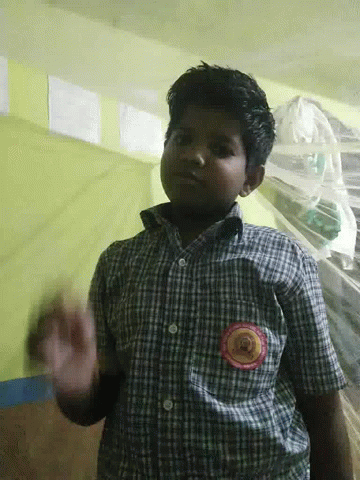 A Boy Wearing A Plaid Shirt Has A Badge On His Chest That Says ' Kerala ' GIF