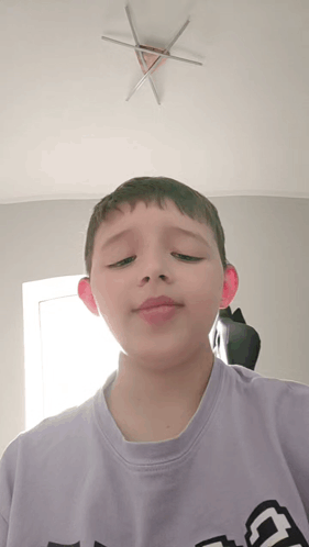 A Boy Wearing A Purple Shirt With The Letter G On It GIF