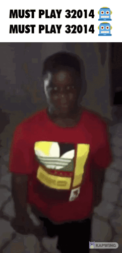 A Boy Wearing A Red Adidas Shirt Stands In Front Of A Sign That Says Must Play 32014 GIF