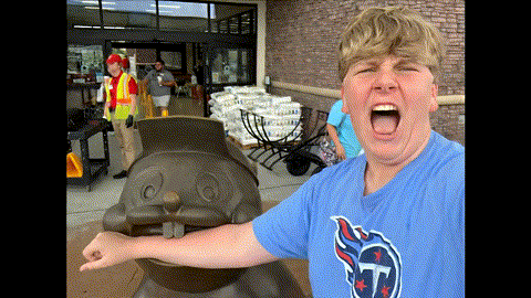 A Boy Wearing A Texans Shirt Stands In Front Of A Statue GIF
