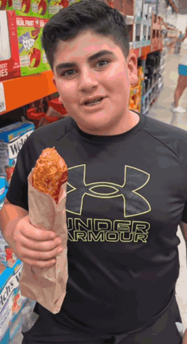 A Boy Wearing An Under Armour Shirt Is Holding A Fried Chicken GIF